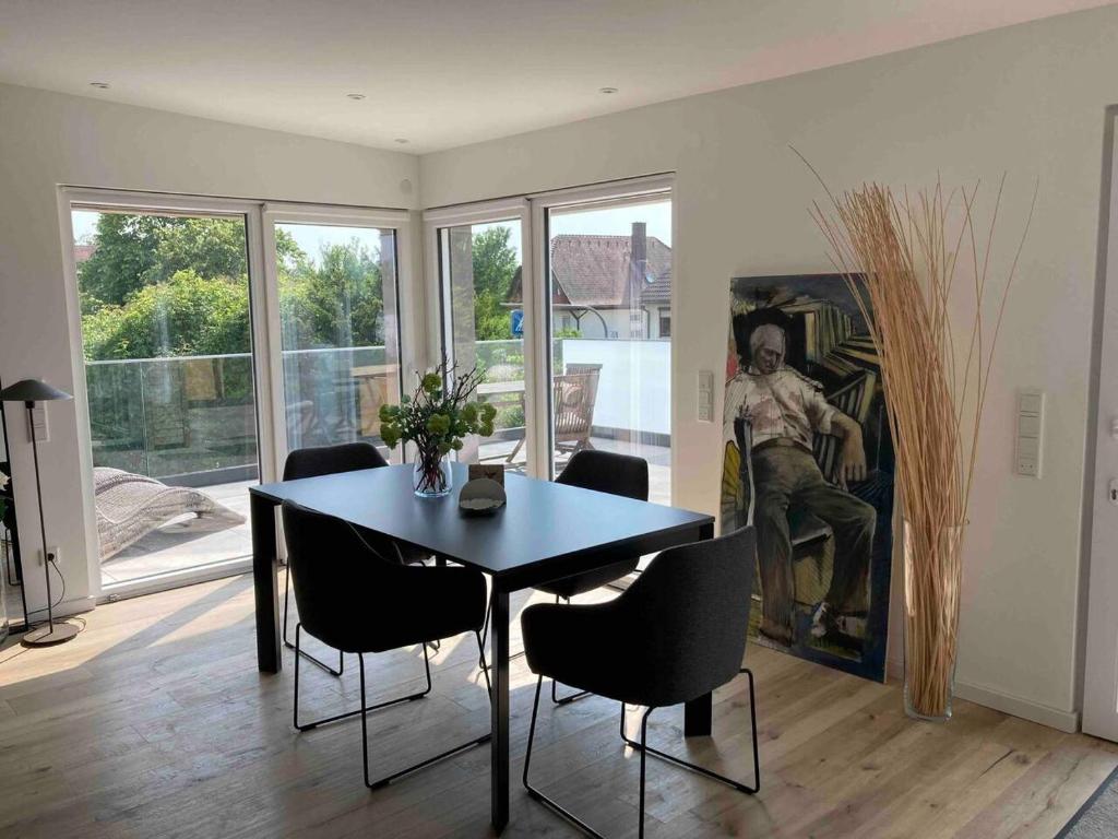 a dining room with a table and chairs and a painting at Neues Penthouse-Loft mit KONUSKarte für gratis ÖPNV in Ehrenkirchen