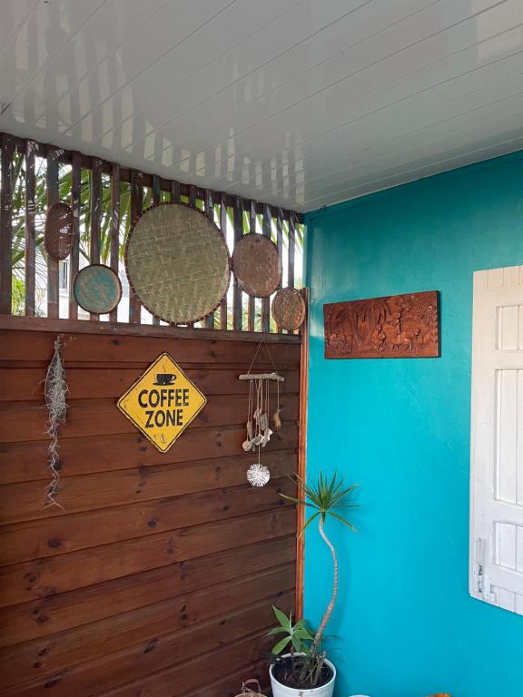 Habitación azul con un letrero de café en la pared en Caze bois flotté, en Petite Île