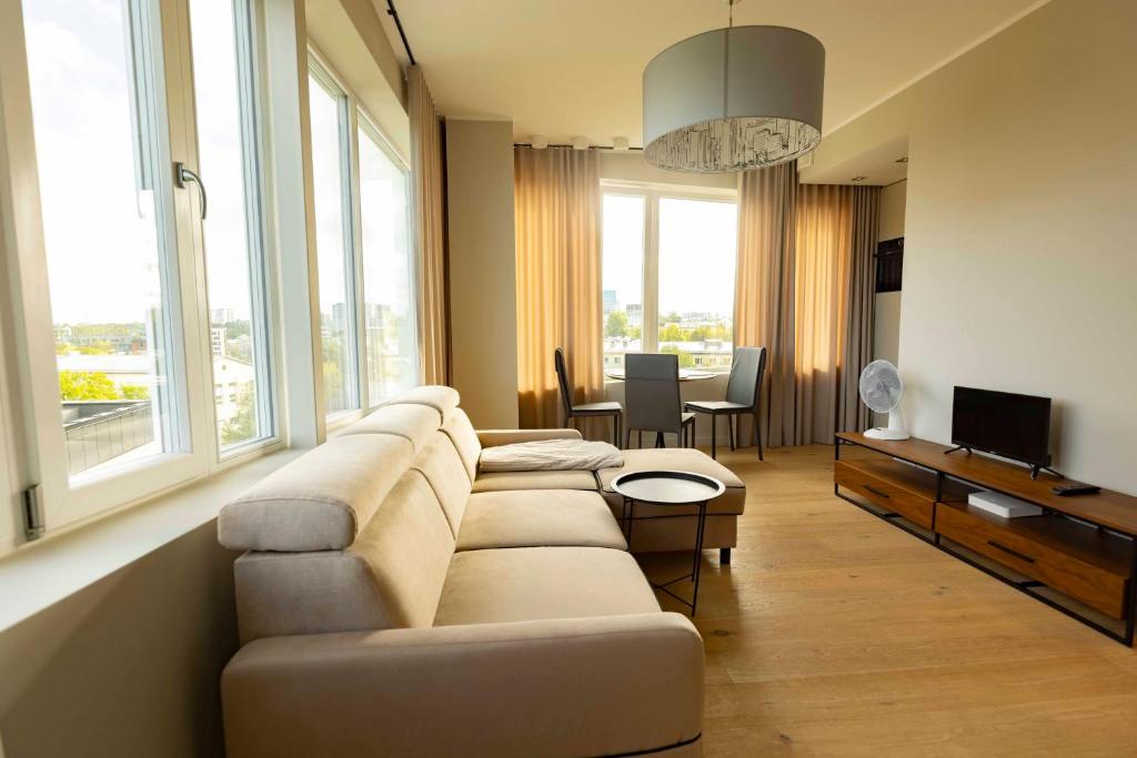 ein Wohnzimmer mit einem Sofa und einem TV in der Unterkunft Beautiful apartment next to the Kalev Stadium in Tallinn