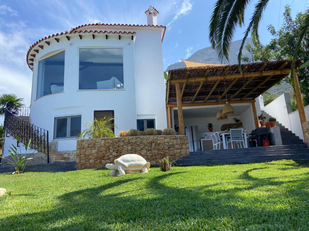 a house with a stuffed turtle laying in the grass at Casa Avellana 37 in Denia