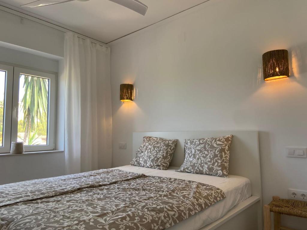 ein Schlafzimmer mit einem Bett mit zwei Kissen und einem Fenster in der Unterkunft Casa Avellana in Denia