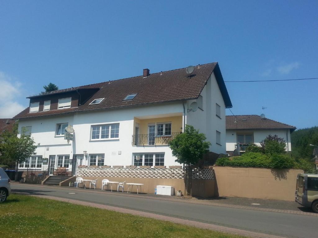 een wit huis met een bruin dak bij Pension Hermes in Wallenborn