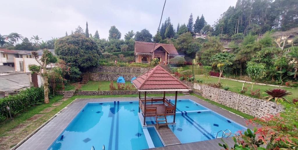 eine Aussicht auf einen Pool mit einem Haus in der Unterkunft Villa Jati in Cimandala