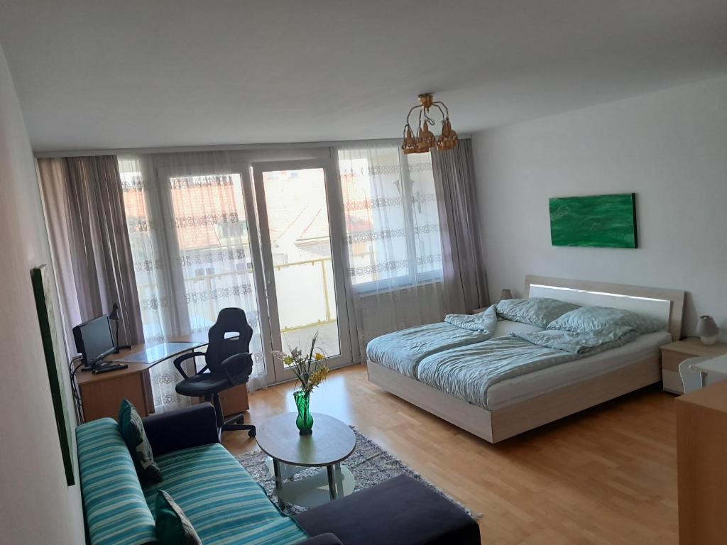 ein Schlafzimmer mit einem Bett, einem Sofa und einem Tisch in der Unterkunft Serviced Apartment with Sunny Balcony in Wien