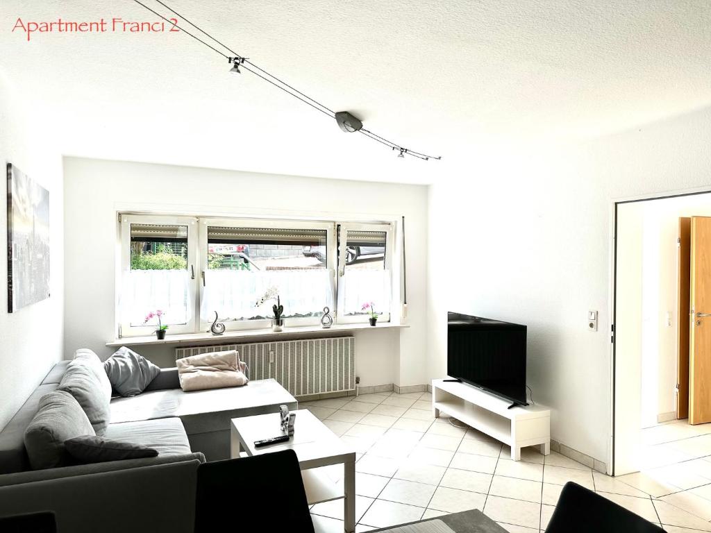 un soggiorno con divano e TV di Apartment Franci a Wiebelskirchen