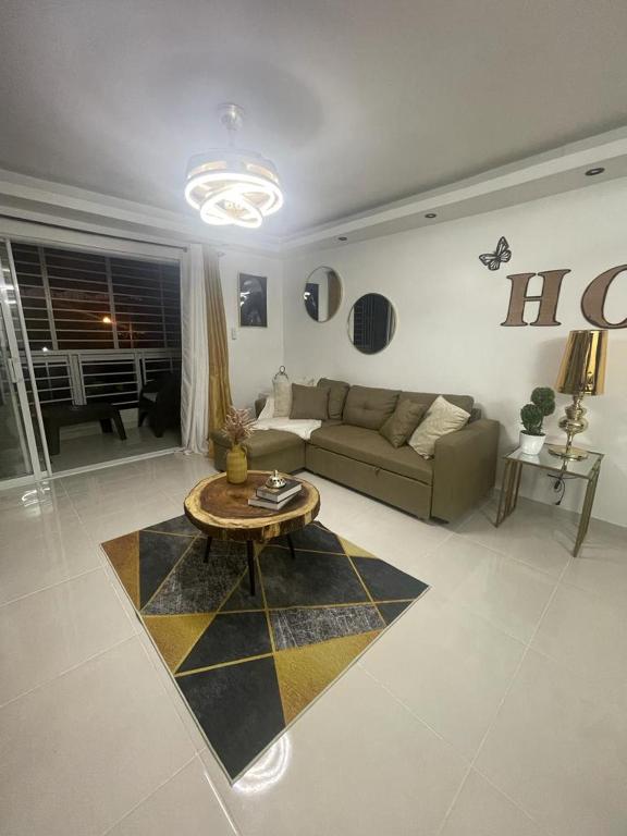 ein Wohnzimmer mit einem Sofa und einem Tisch in der Unterkunft Garden city apartamento de 3 habitaciones in Santo Domingo