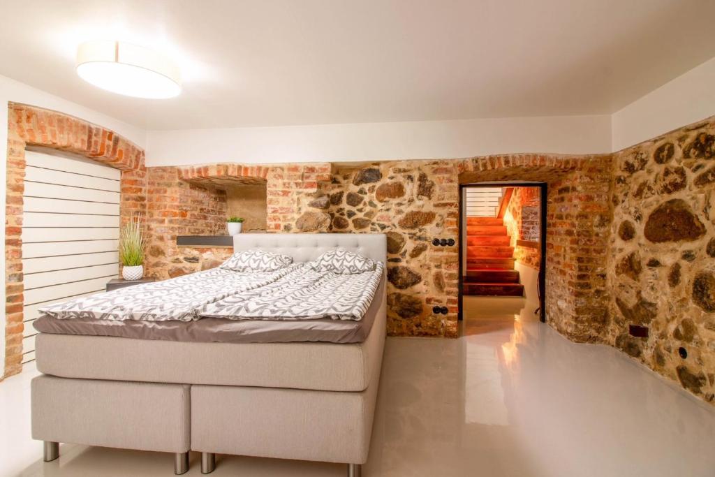 a bedroom with a bed and a stone wall at Old Town Luxury apartment with sauna in Tartu