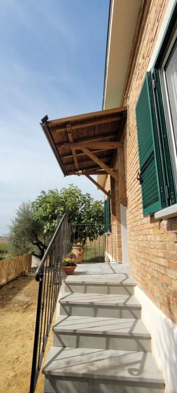 een trap naar een gebouw met een groene luik bij Villa immersa nelle colline toscane, vista vigneto in Cortona