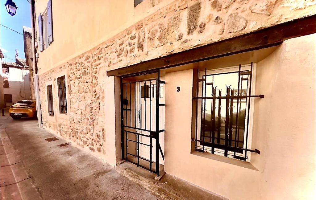 un bâtiment avec des portes en fer forgé dans une rue dans l'établissement Studio T2 Montfrin Pont du Gard, à Montfrin