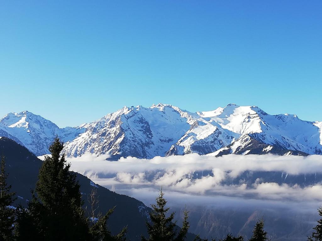 une vue sur une montagne enneigée avec des nuages au premier plan dans l'établissement le panoramic, à L'Alpe-d'Huez