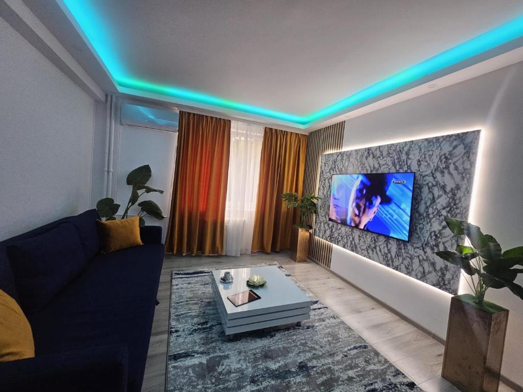 a living room with a couch and a tv on a wall at Cazare Ploiesti in Ploieşti