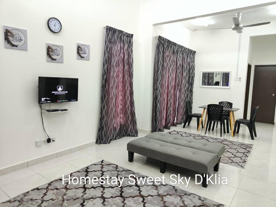 Homestay KLIA Sweet Sky في سيبانغ: غرفة معيشة مع أريكة وتلفزيون