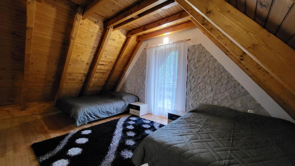 a attic bedroom with a bed and a window at Cozy Cottage Vlašić in Vlasic
