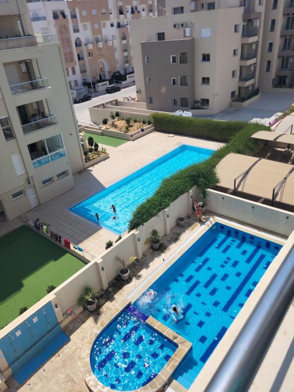uma vista panorâmica de duas piscinas num edifício em Charmant appartement - residence avec piscine entre Hammamet et Nabeul em Nabeul