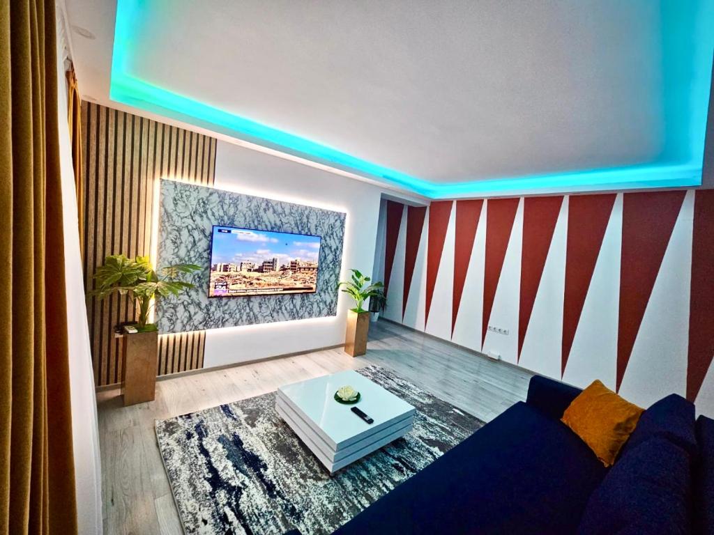 a living room with a blue couch and a tv at Apartament Ploiești in Ploieşti