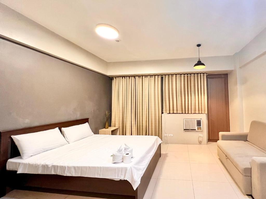 una camera d'albergo con letto e divano di Elegant Condo Hotel across NAIA Airport Terminal 3 Newport City a Manila
