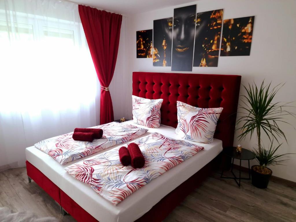 1 dormitorio con 1 cama grande y cabecero rojo en Mefady Ferienhaus mit Massagesessel en Stadtkyll