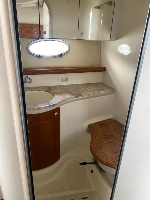 un piccolo bagno con lavandino e specchio di BATEAU CONFORT 12 Mètres a Saint-Cyprien