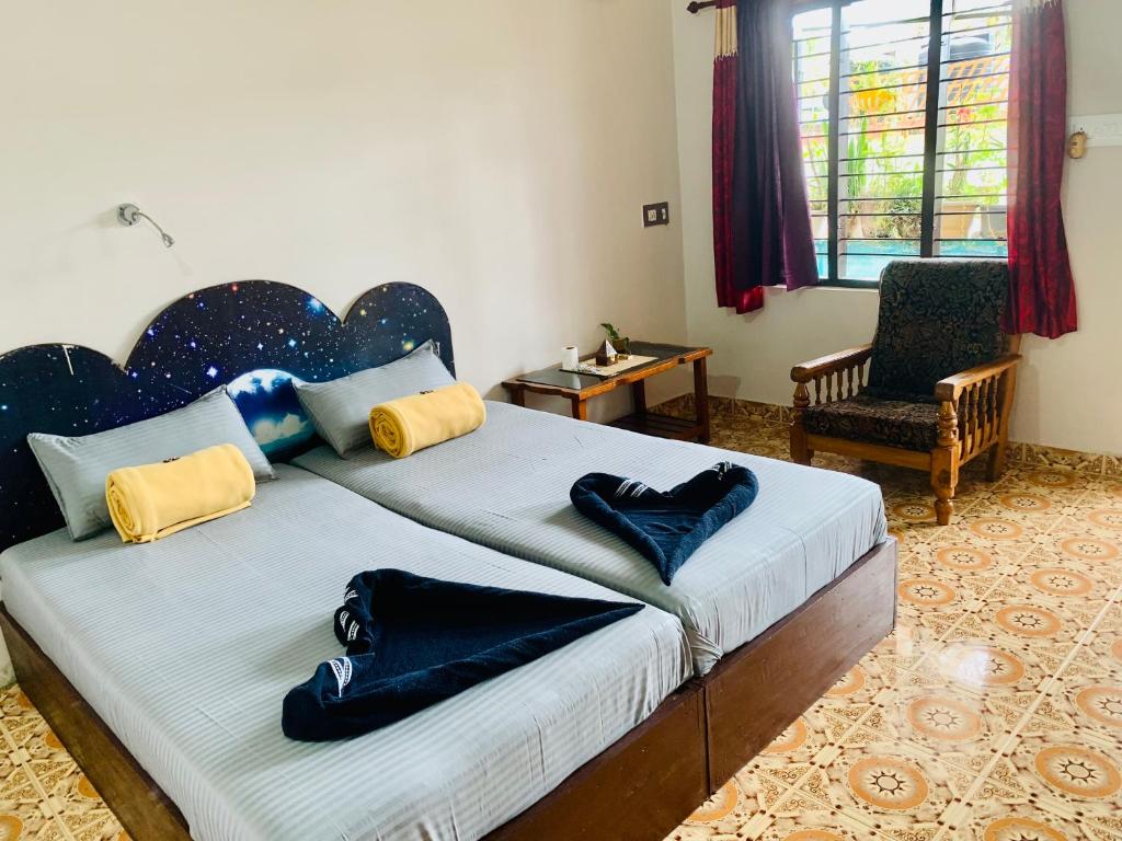 a bedroom with a bed with blue and yellow pillows at Mountain View Homestay in Thekkady
