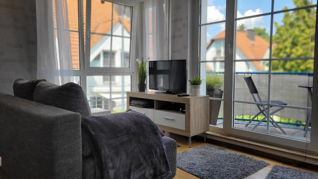 a living room with a couch and a tv on a stand at Berlin-Oase - schnuckelige Ferienwohnung an der Grenze zu Berlin in Schönefeld