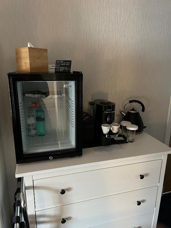 a white dresser with a tv on top of it at Lochindaal Hotel in Port Charlotte