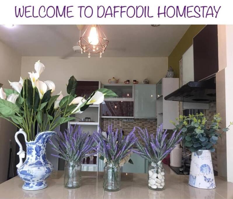 a group of vases sitting on a table with flowers at Daffodil Homestay in Perlis in Kangar
