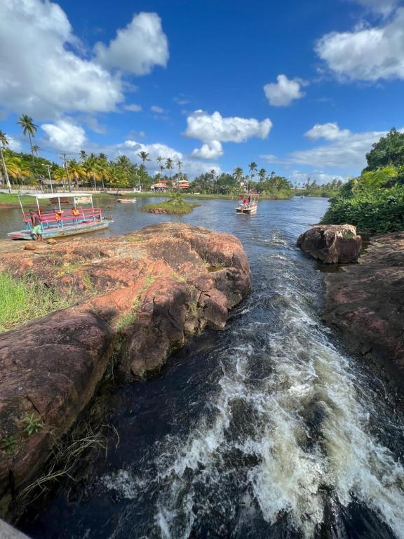 zwei Boote auf einem Fluss mit Felsen im Wasser in der Unterkunft Village Ninho da Jandaia in Mata de Sao Joao