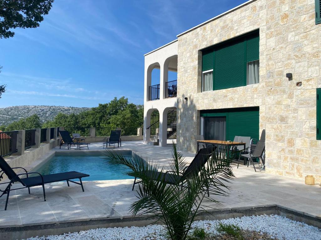 uma casa com piscina ao lado de um edifício em Villa Sani em Bribir