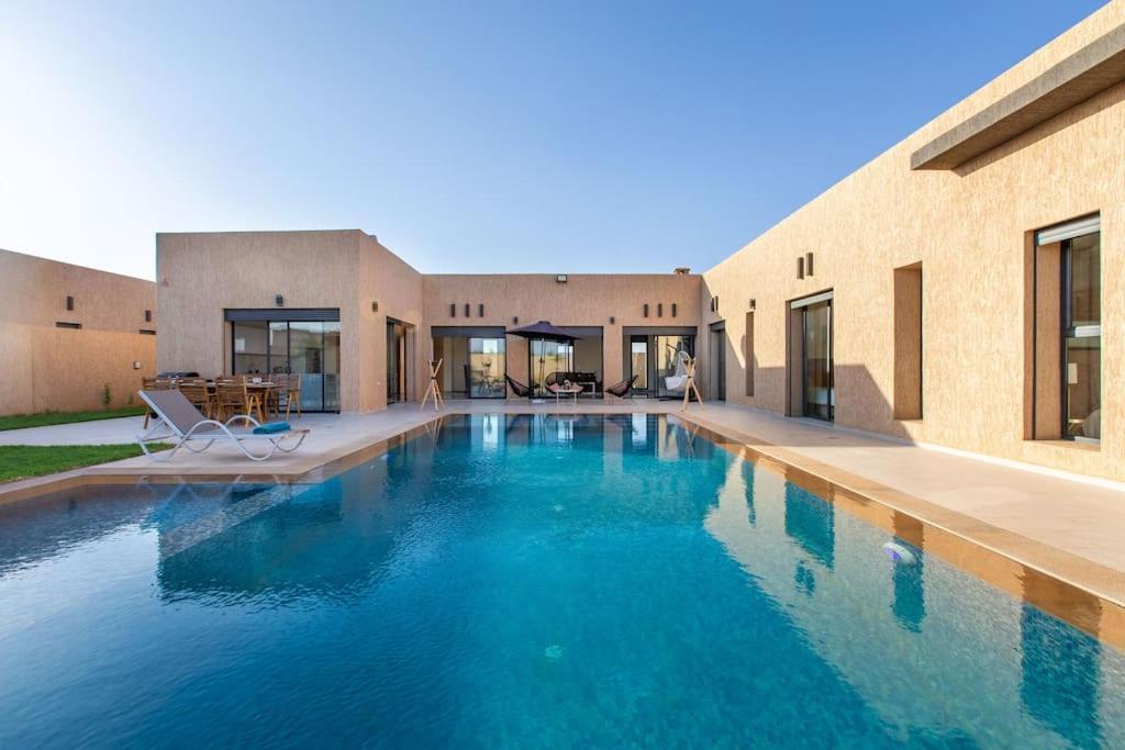 une piscine devant une maison dans l'établissement Villa Kassia , Jacuzzi, Hamman, jeux…, à Marrakech