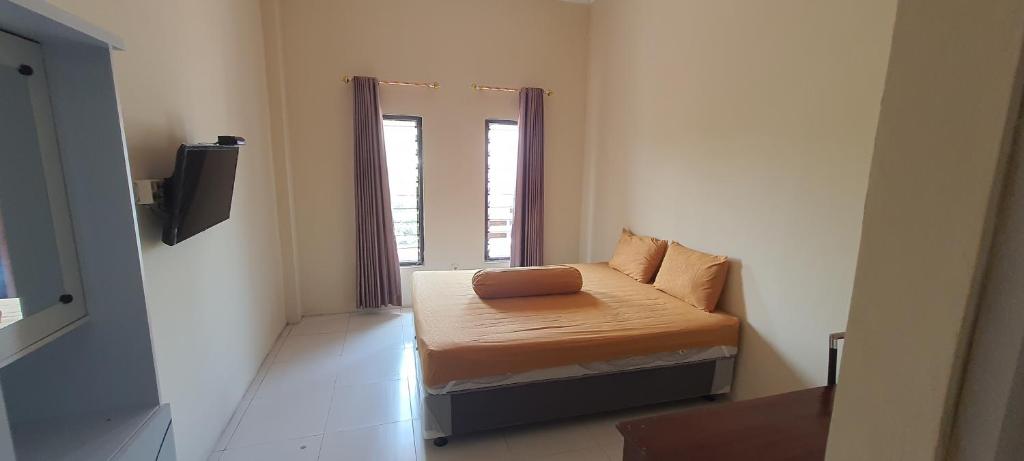 Postel nebo postele na pokoji v ubytování Solo Nadamax City Guest House Syariah