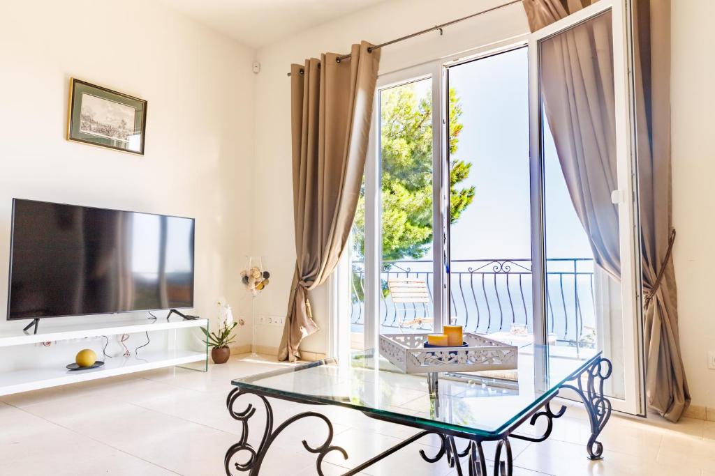 a living room with a glass table and a large window at Sea terace apartment between Nice and Monaco - 3 in Villefranche-sur-Mer