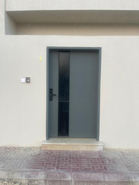 une porte sur le côté d'un bâtiment blanc dans l'établissement الشقة الفاخرة vip العيينة, à Al ‘Uyaynah