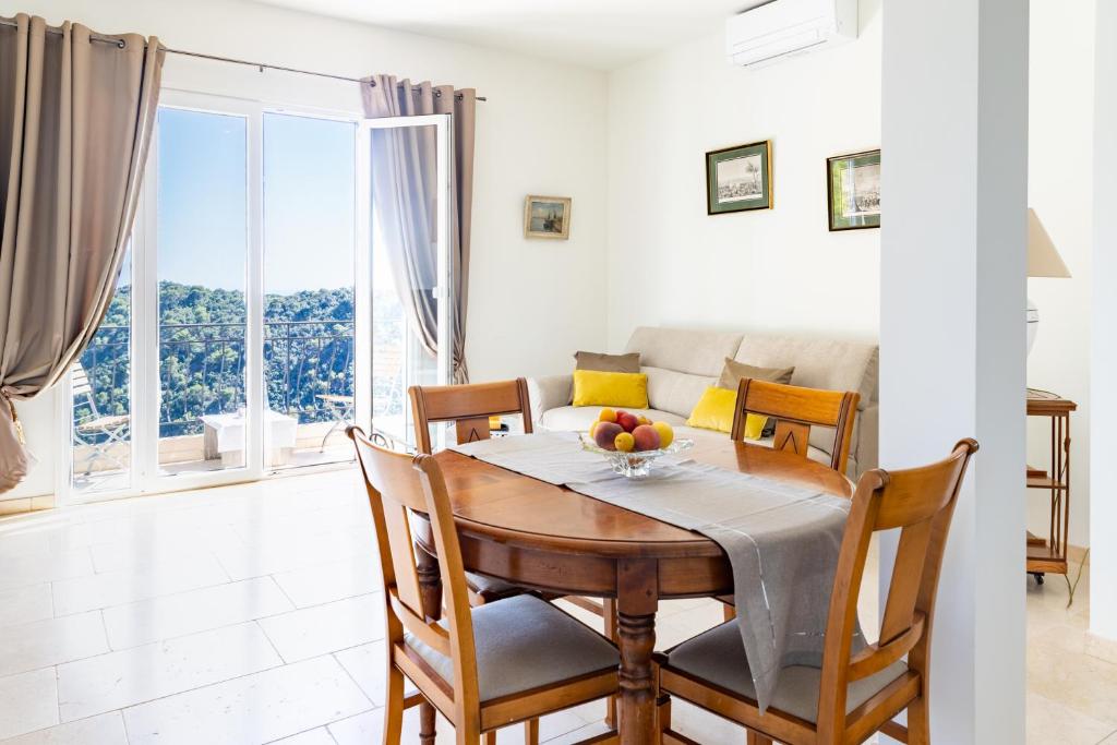 a dining room with a table and chairs and a couch at Sea terace apartment between Nice and Monaco - 3 in Villefranche-sur-Mer