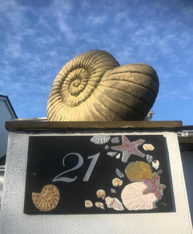 a sign with a shell on top of a building at Beach Road- short walk to Charlestown, Carlyon Bay & coastal paths- dog friendly in Carlyon Bay