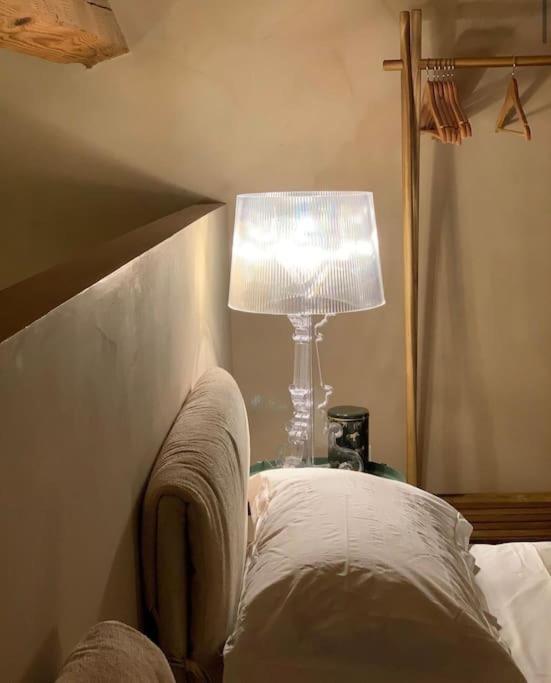 a lamp sitting on a table next to a bed at Olivietta Suite in Cervia