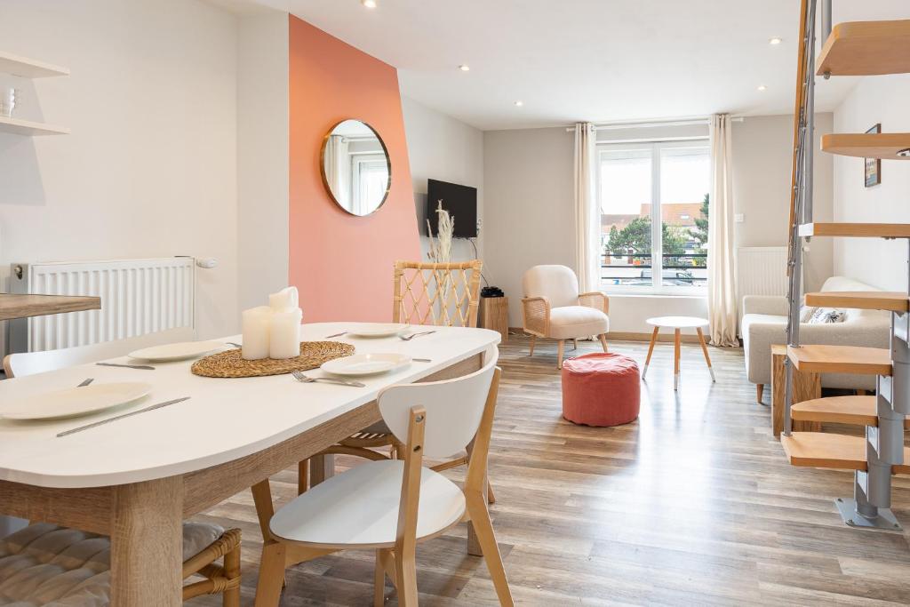 a dining room and living room with a table and chairs at Duplex Petit-Fort - proche plage in Gravelines