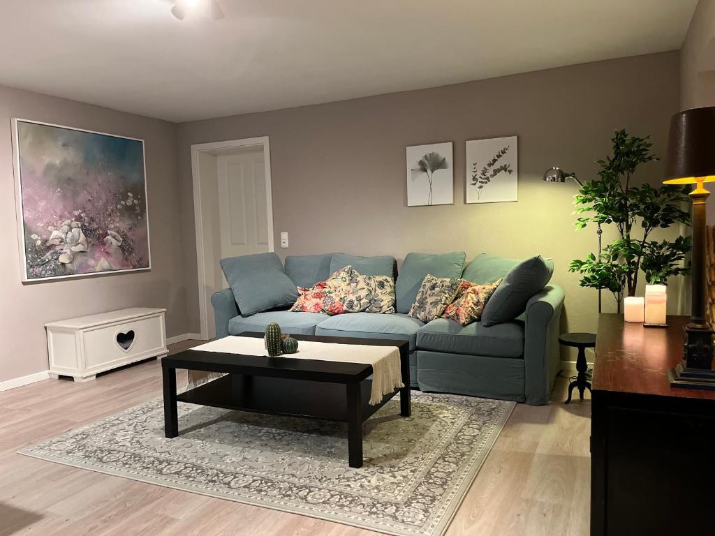 ein Wohnzimmer mit einem blauen Sofa und einem Couchtisch in der Unterkunft Gemütliche Ferienwohnung, See- und Stadtnah in Schwerin