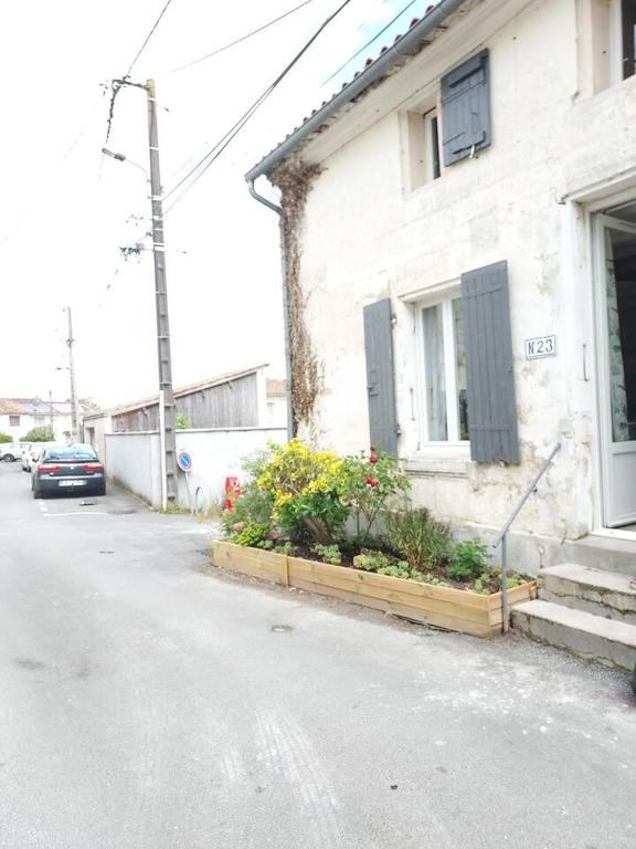 une maison avec quelques fleurs sur le côté d'une rue dans l'établissement Maisonnette, à Saintes