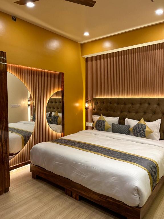 The Origin Suites DLF MY PAD في لاكناو: غرفة نوم بسرير كبير ومرآة