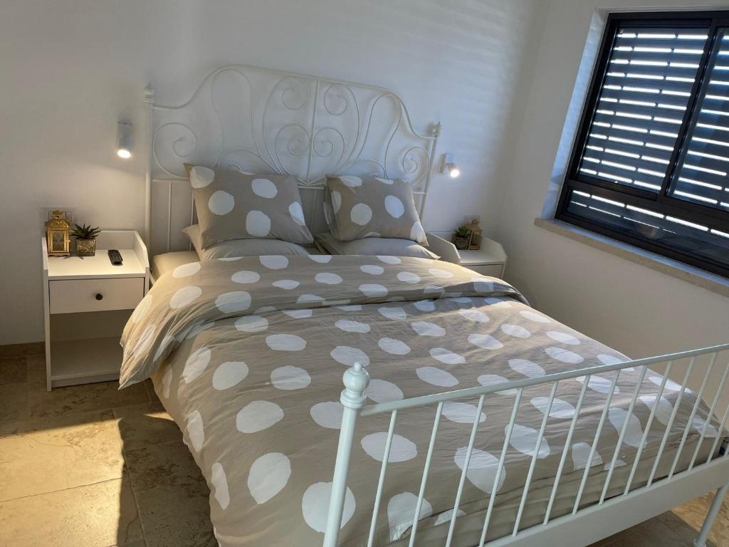 1 dormitorio con cama blanca y cabecero blanco en מון-שיר הגושרים, en Hagoshrim