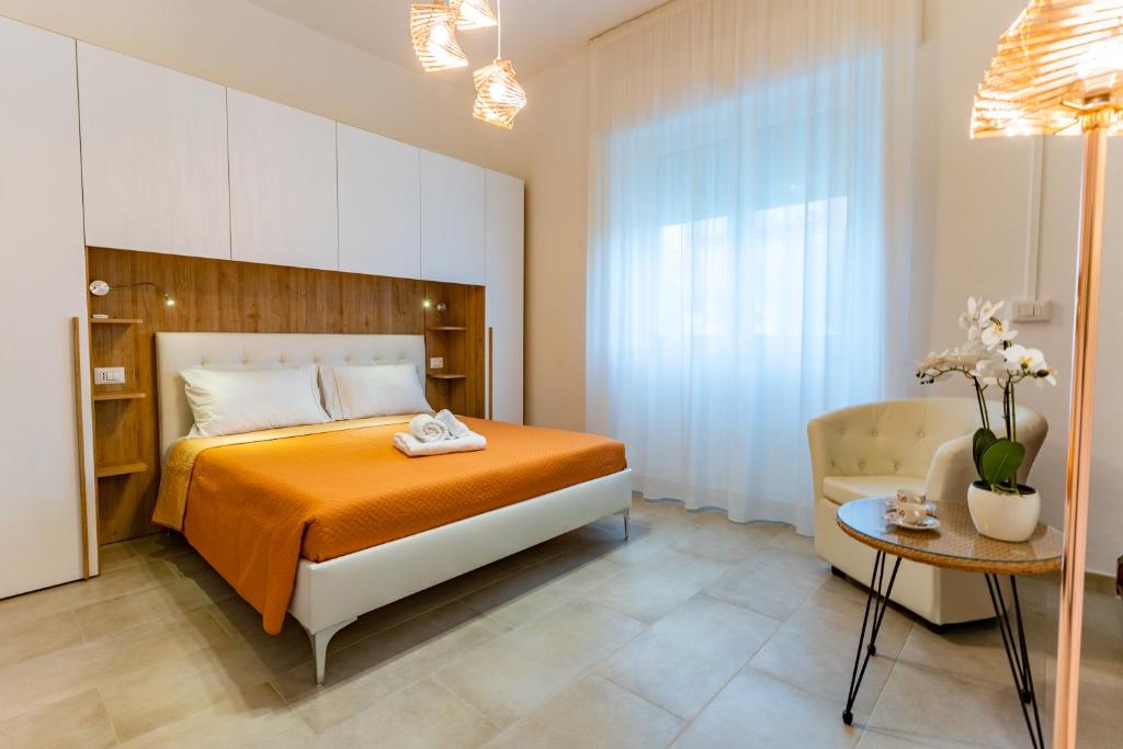 um quarto com uma cama laranja e uma mesa em Doctor Guest House em Tortolì