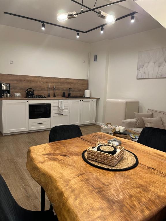 a living room with a table and a kitchen at Apartamenty Aleja Jana Pawła II in Wągrowiec