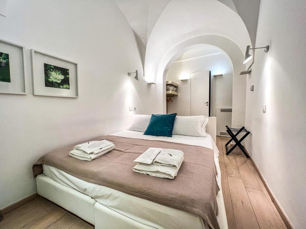 1 dormitorio con 1 cama con toallas en Santacroce Luxury Rooms, en Lecce