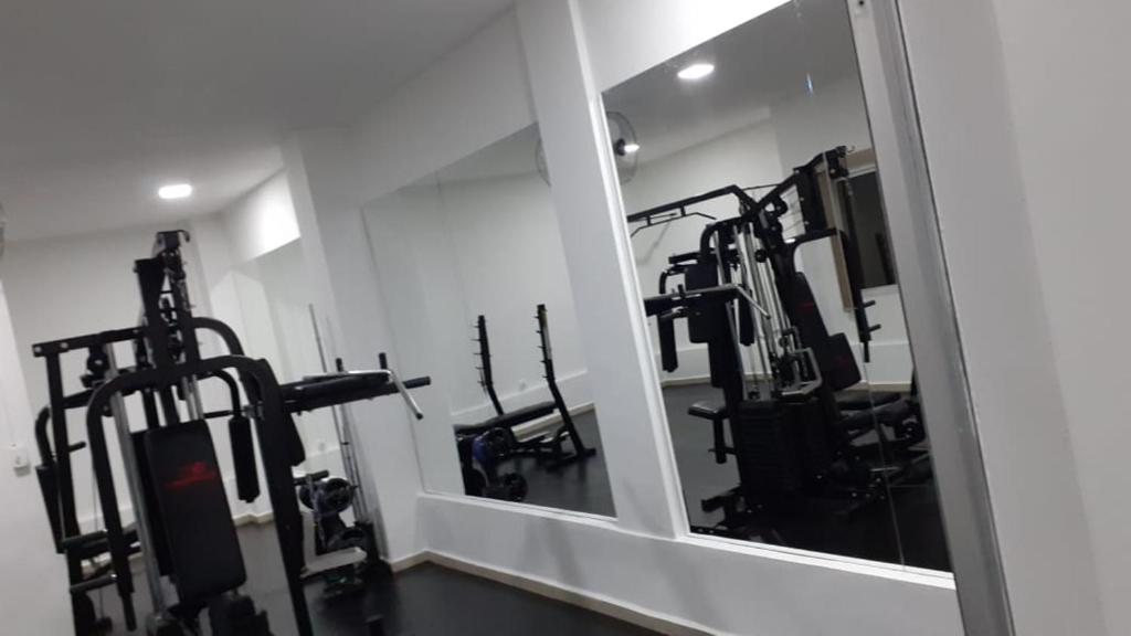 a gym with several treadmills and a mirror at Ap ótima localização in São José dos Campos
