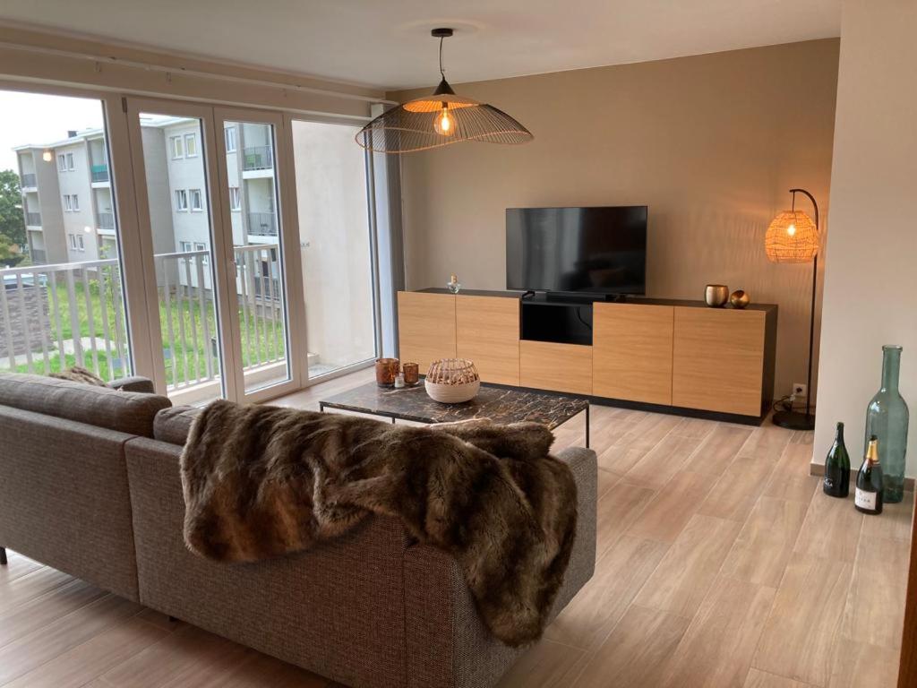 a living room with a couch with a faux fur blanket at Appartement moderne flambant neuf 
