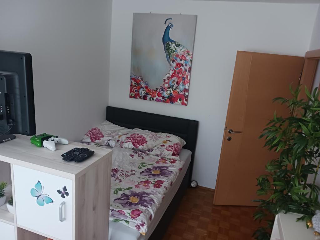 a bedroom with a bed and a picture of a peacock at Maxi's Home in Marchtrenk