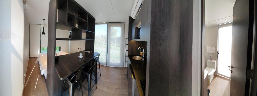 a room with a kitchen with a counter and a table at Cabañas y Padel Tinycolchagua cl in Santa Cruz