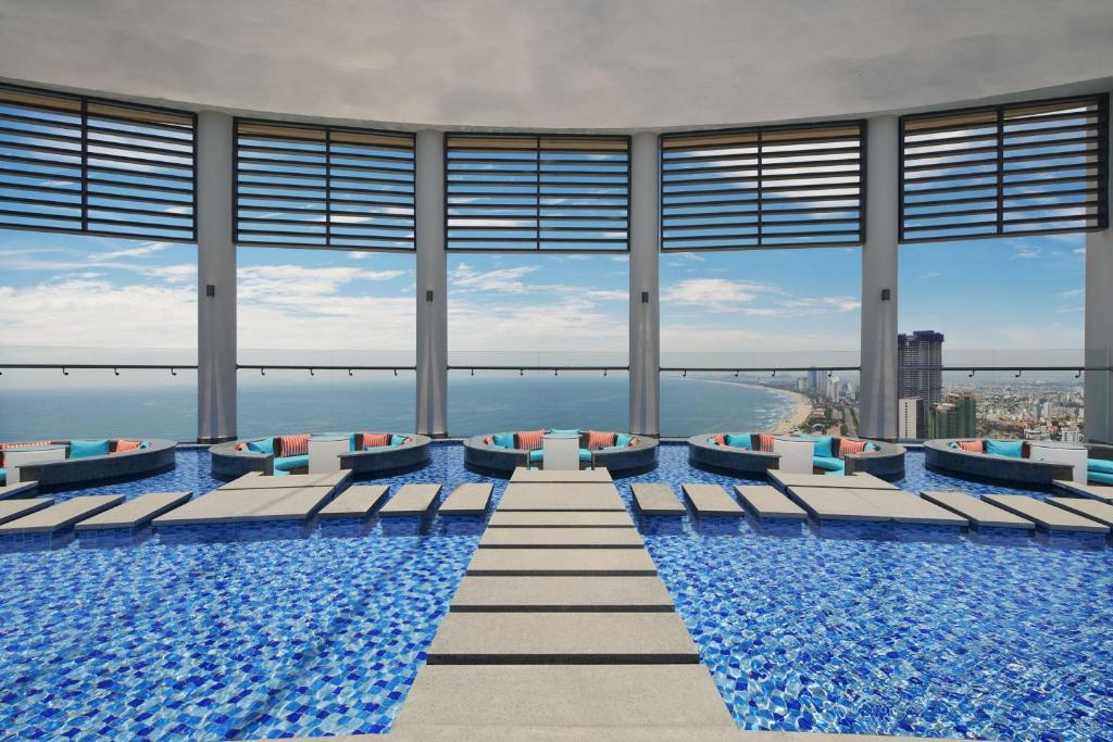a swimming pool with chairs and a view of the ocean at Four Points by Sheraton Danang in Danang