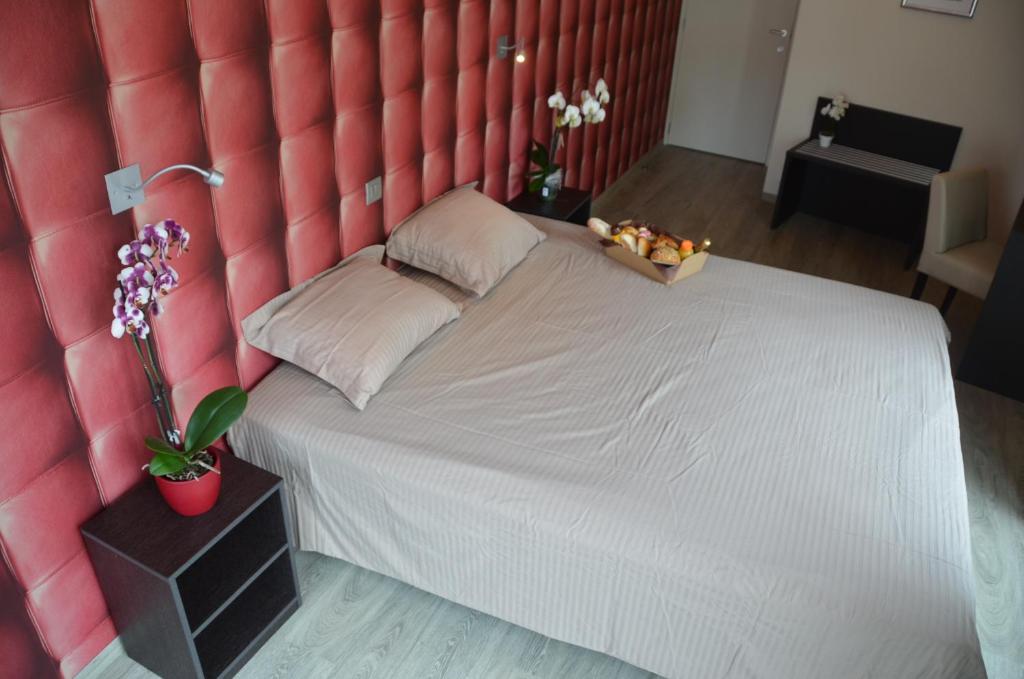 1 dormitorio con 1 cama blanca grande y cabecero rojo en Logies Bocadillo, en Blankenberge