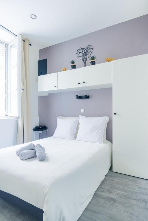une chambre avec un lit blanc avec deux serviettes dessus dans l'établissement L'ELEDAURAT - Centre ville Riom - Idéal professionnel - Proche Clermont Ferrand, à Riom